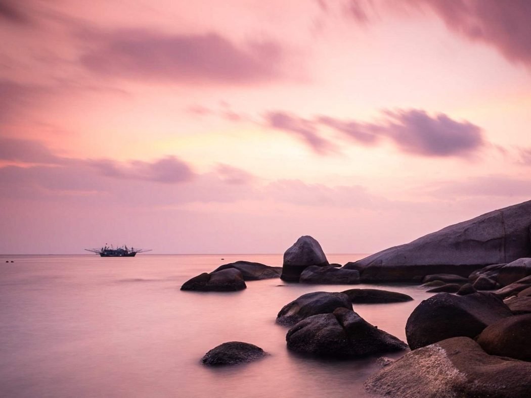 Long exposure shot of a quiet rocky spot by the sea in Koh Tao at sunset – How to Travel to Thailand Without Leaving Home – A World to Travel